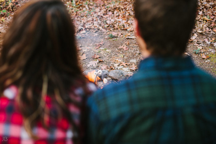 engagement session in the woods, surrounding a fire with smores and flannel in autumn