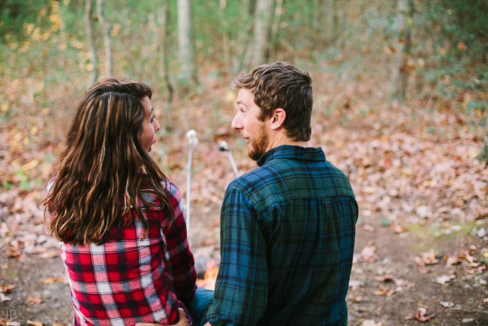 engagement session in the woods, surrounding a fire with smores and flannel in autumn
