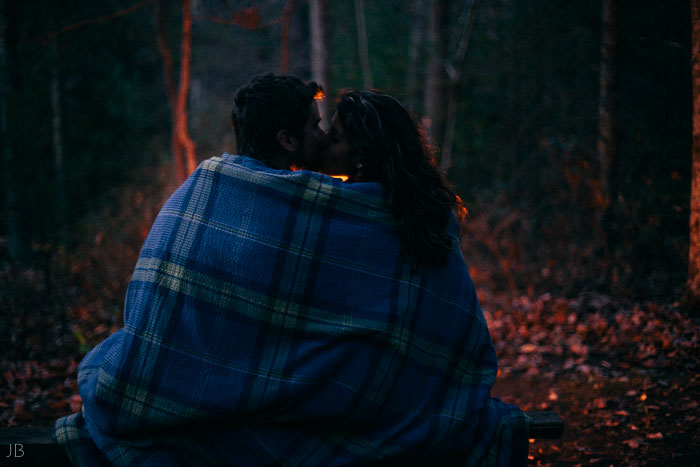 engagement session in the woods, surrounding a fire with smores and flannel in autumn