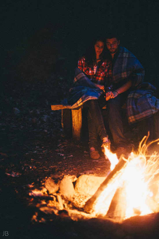 engagement session in the woods, surrounding a fire with smores and flannel in autumn