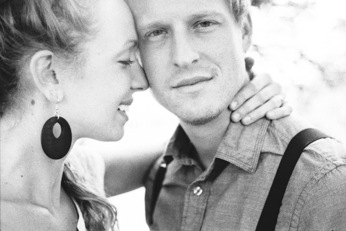 dreamy vintage engagement in an orchard kiss behind vintage straw hat camera color film fuji400h medium format vibrant