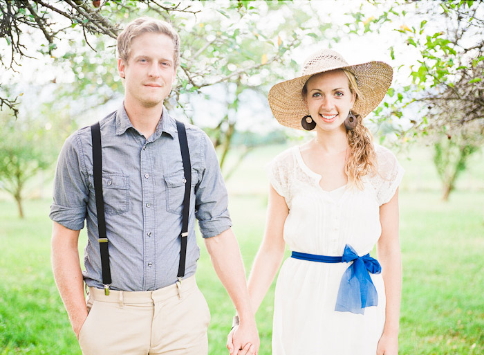 dreamy vintage engagement in an orchard kiss behind vintage straw hat camera color film fuji400h medium format vibrant