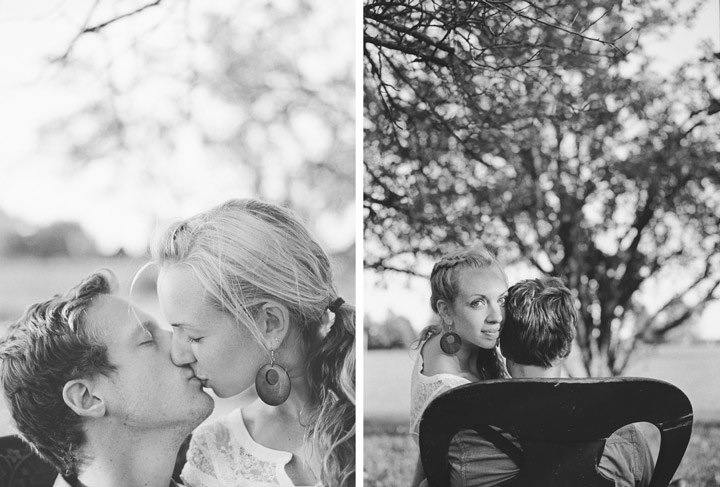 engaged couple sit together in an orchard in an antique chair film kodak tri-x