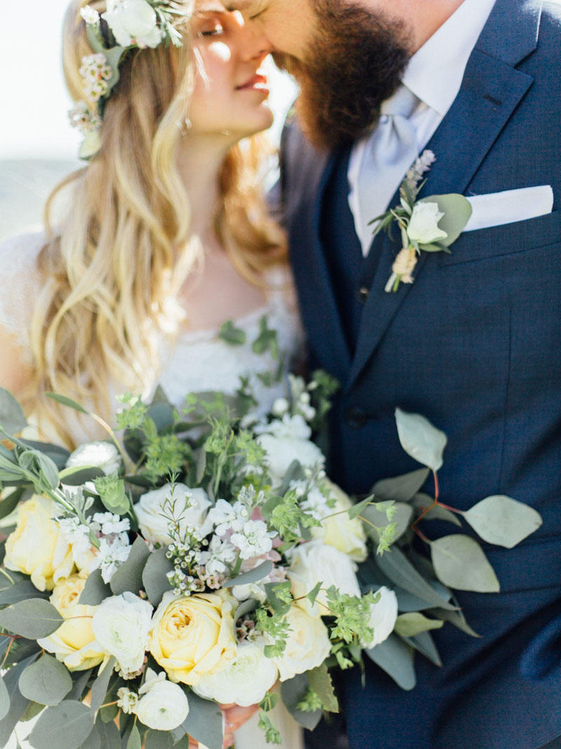 bride and groom kiss behind florals - big sur california wedding