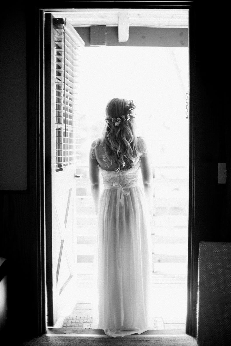 black and white bride stands in doorway waiting for her wedding - big sur california wedding