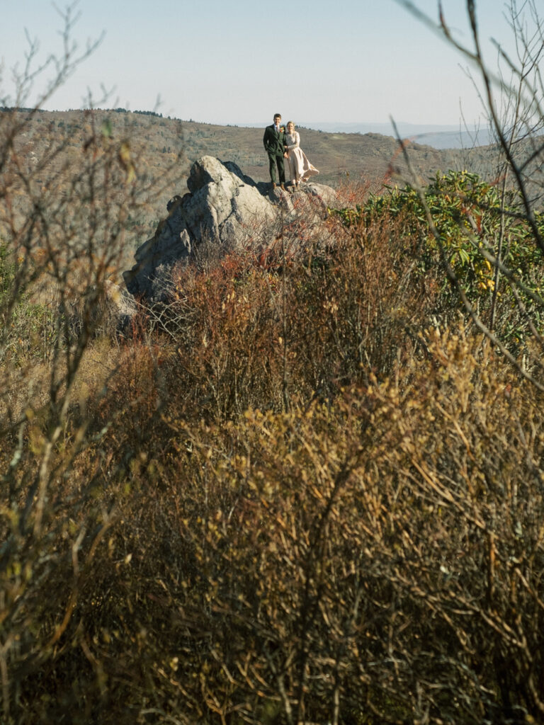 bride and groom standing on rock at sunrise wedding in Grayson Highlands - natural edit