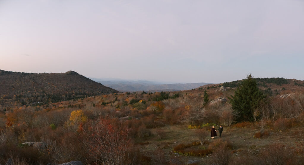 bride and groom walking through meadow at sunrise wedding in Grayson Highlands - natural edit - fall foliage