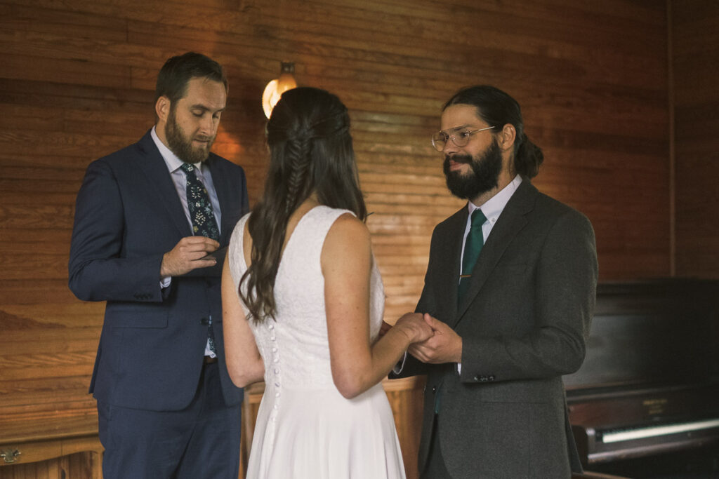 groom smiling at bride during wedding ceremony at Haines chapel