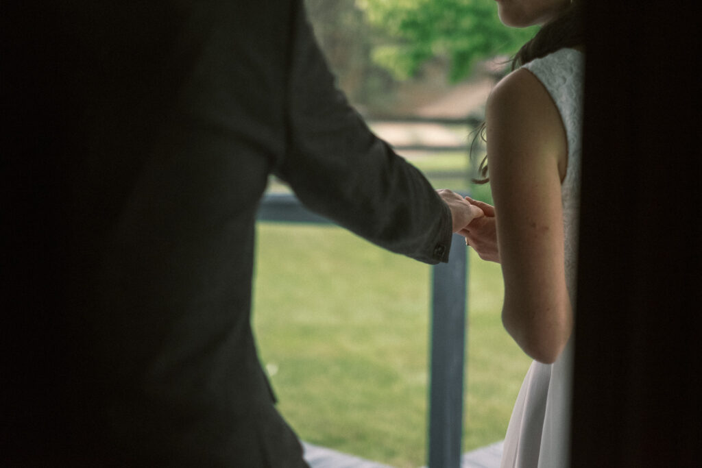 closeup of bride and groom holding hands exiting Haines chapel