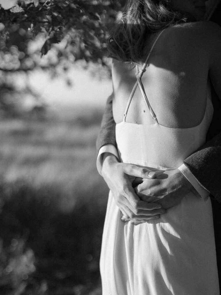 black and white detail of grooms hands hugging bride with goosebumps - Shenandoah National Park elopement - Ilford HP5+ - film based wedding photographer