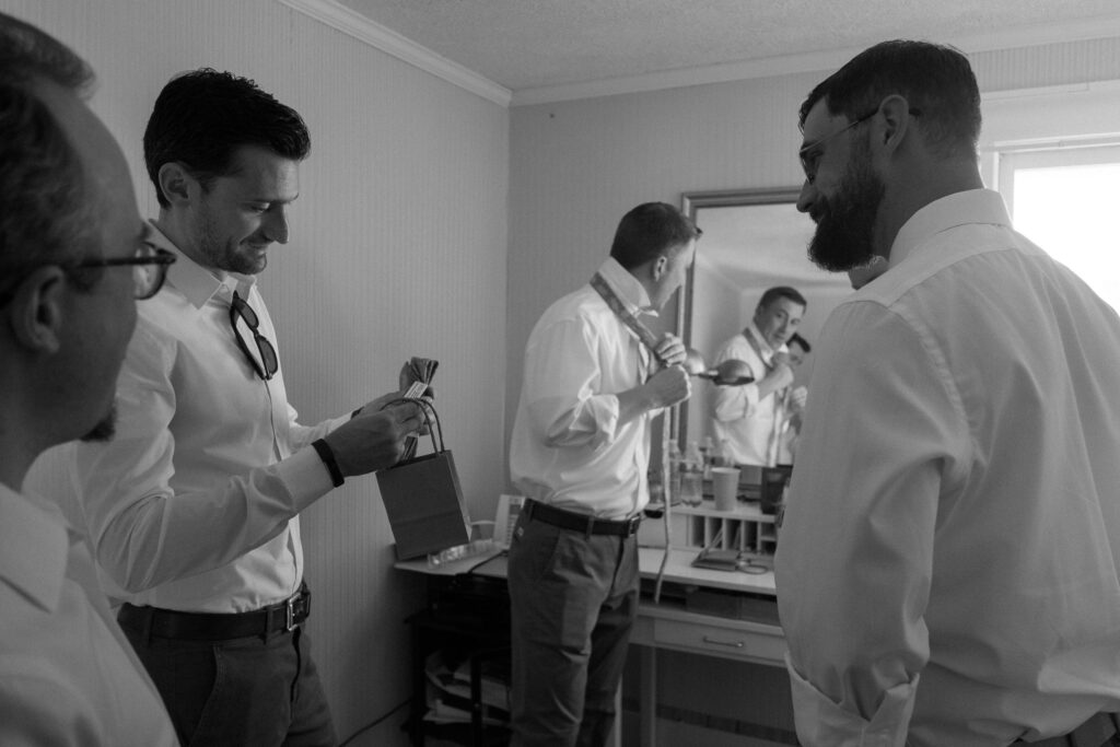 groom giving gifts to groomsmen - Ilford HP5+ black and white film look