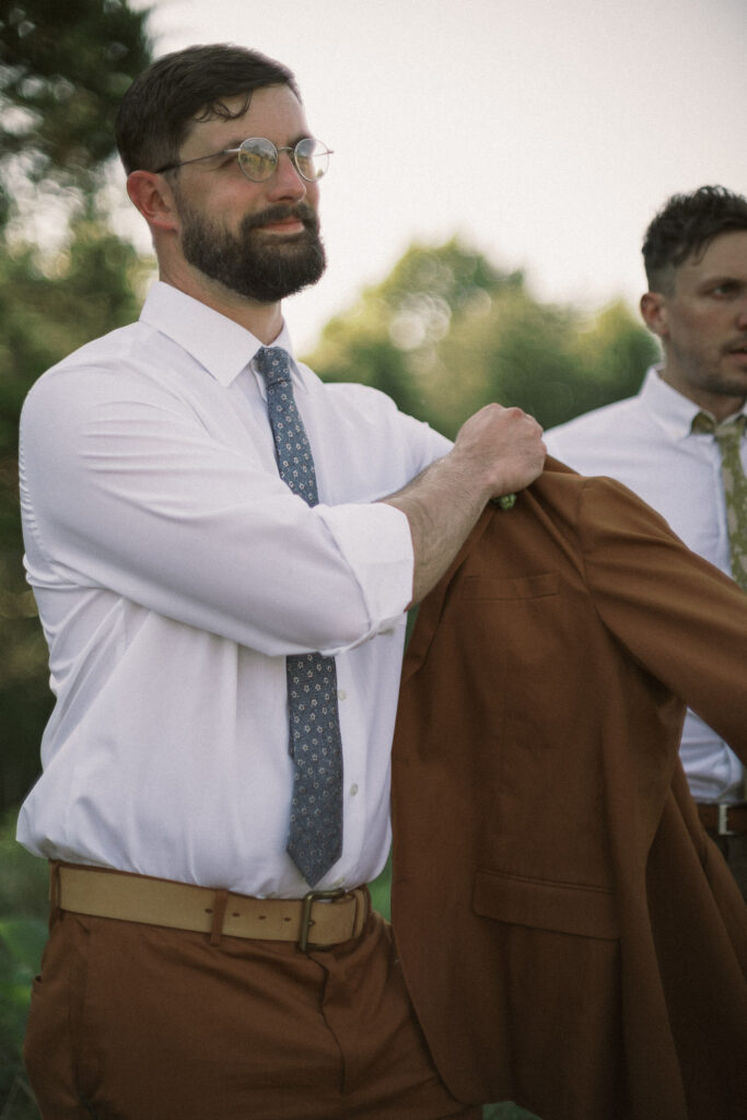 groom putting on jacket - film look 160C Virginia documentary wedding photographer