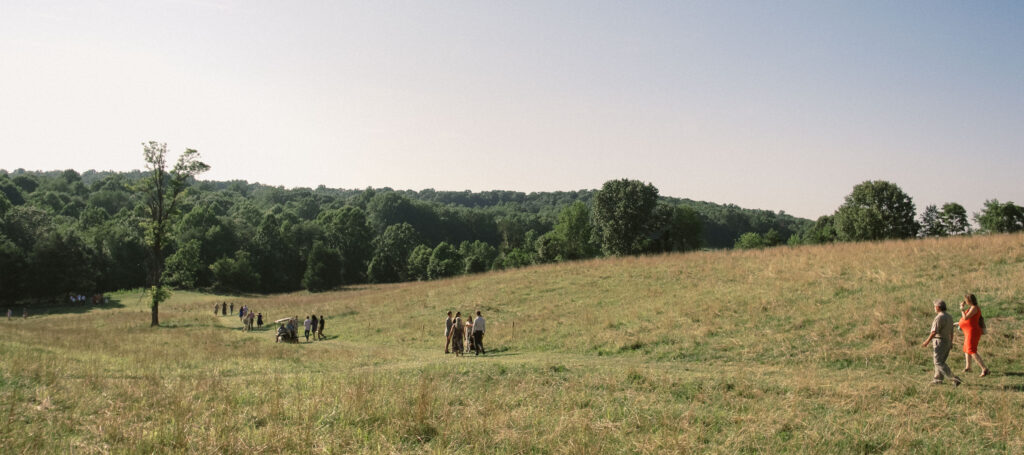 guests walking down hill to outdoor virginia wedding ceremony - film look 160C Virginia documentary wedding photographer