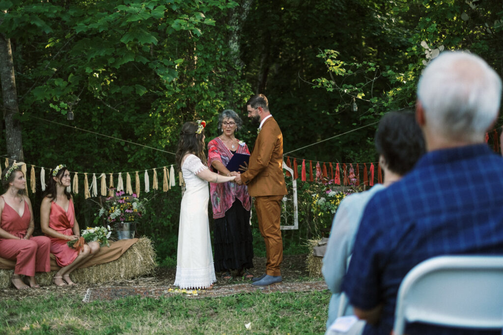 bride and groom holding hands at outdoor wedding ceremony - film look 160C Virginia documentary wedding photographer