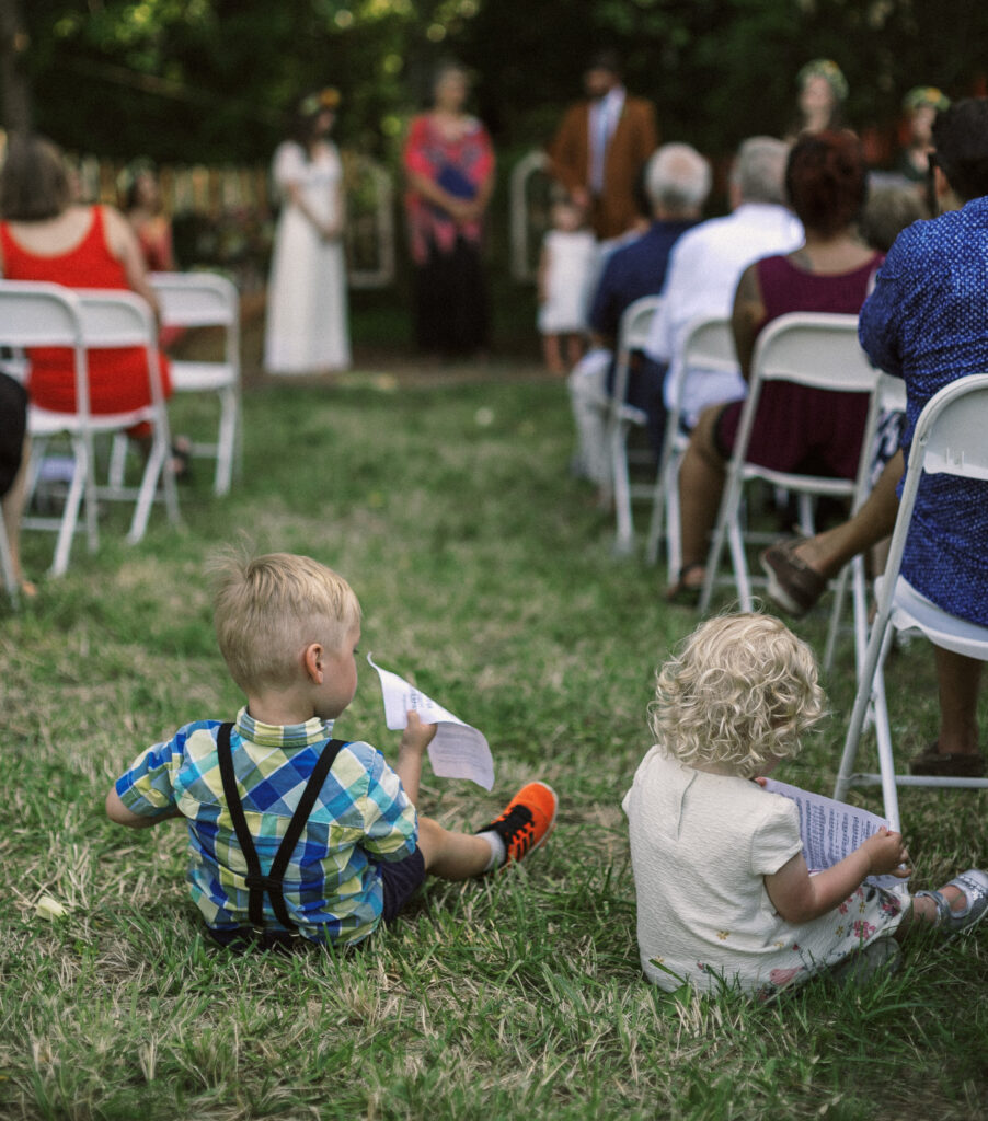 children sitting in aisle at outdoor wedding ceremony in Virginia - film look 160C Virginia documentary wedding photographer