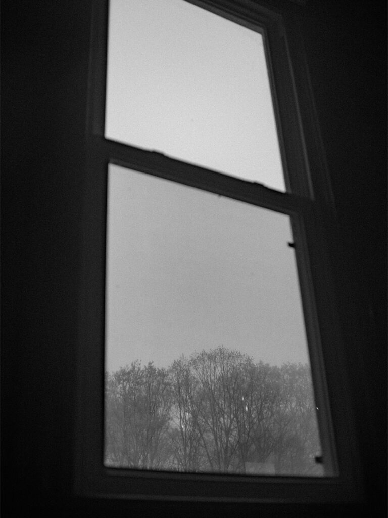black and white photograph - looking out of window at Haines chapel on a rainy day - Ilford HP5+
