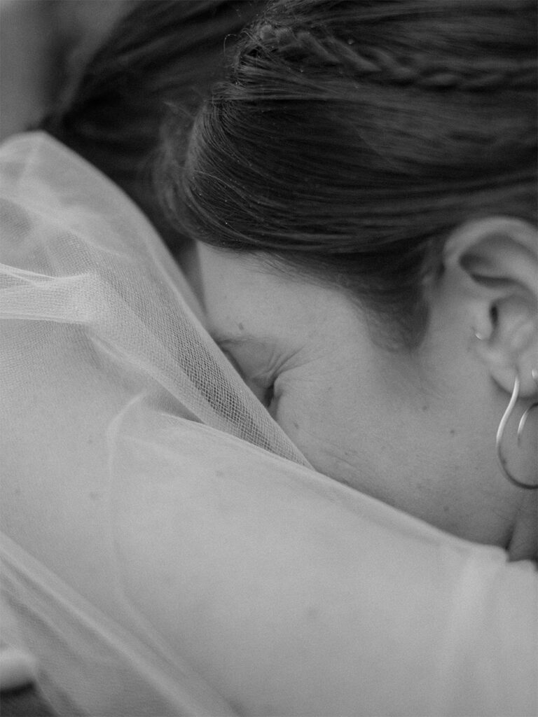 black and white photograph closeup of bride hugging groom with eyes closed - Ilford HP5+