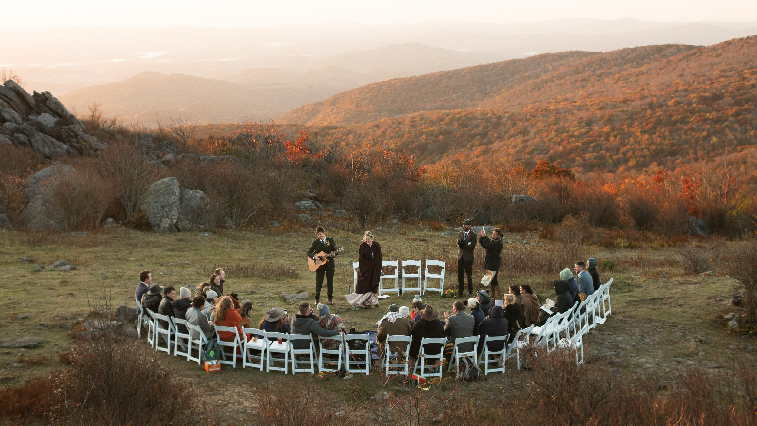 groom playing guitar at autumn sunrise elopement ceremony in the Grayson highlands mountains in Virginia - documentary style hands-off photographer